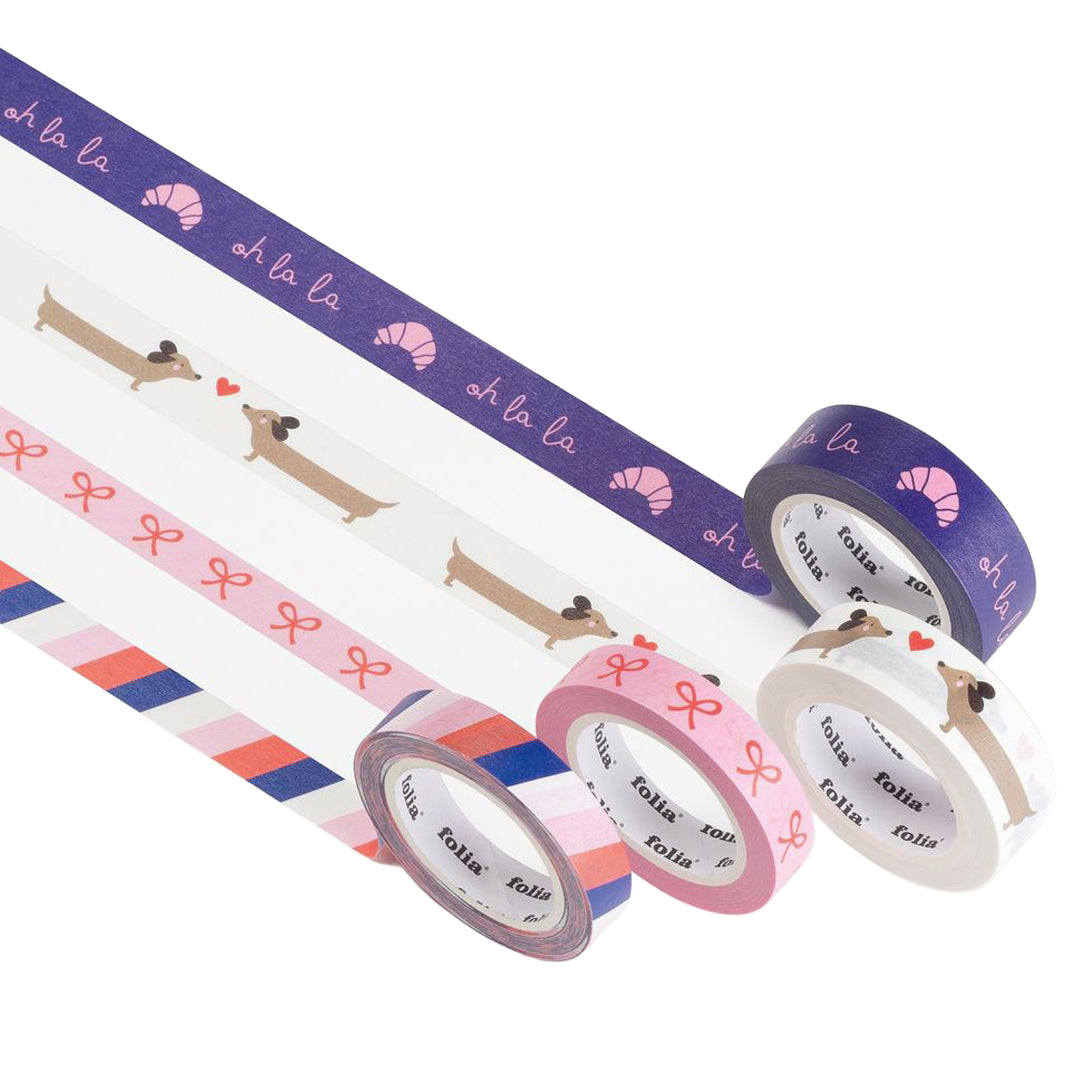 Vier rollen Folia washi tape, deels afgerold, met Parijse patronen van teckels, croissants en strepen.