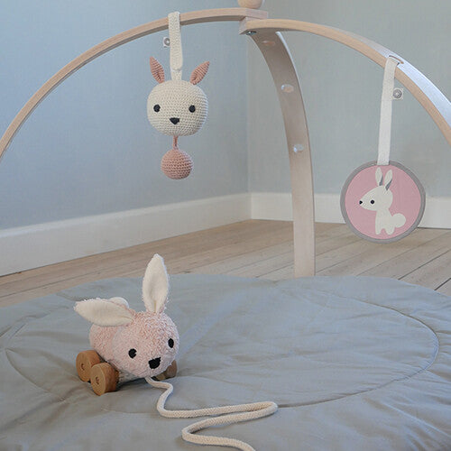 Franck & Fischer gehaakte konijnenrammelaar hangend aan een houten babygym.