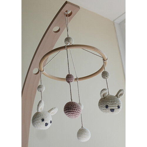 Franck & Fischer babymobiel met gehaakte konijnen en balletjes, hangend aan een houten mobielarm.