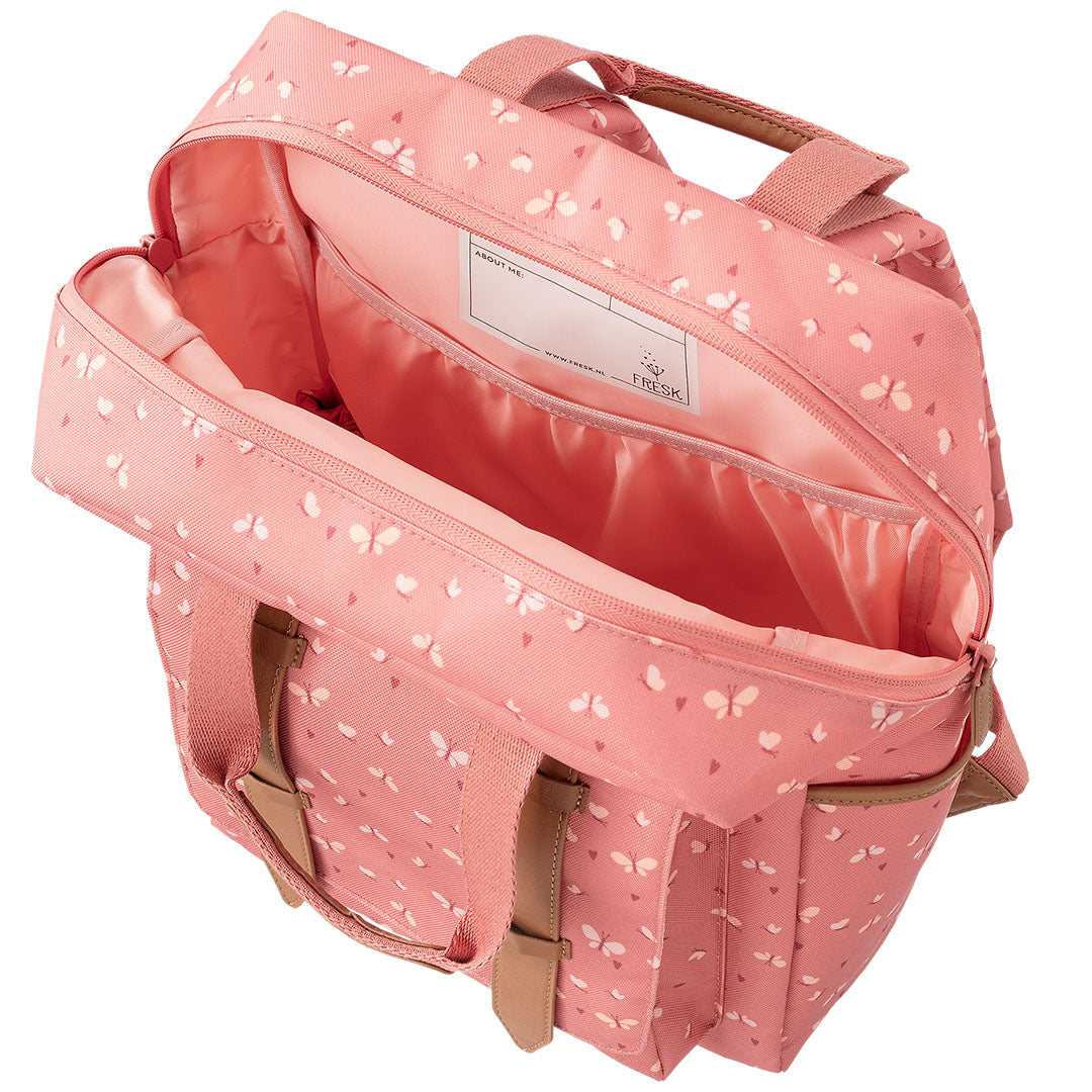 Open roze Fresk peuterrugzak met vlinderpatroon, met zicht op het hoofdvak en een naamlabel.