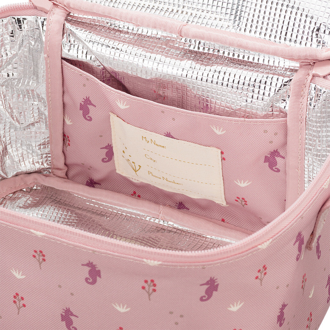 Detail van de open roze koeltas met zeepaardjespatroon en naamlabel aan de binnenkant.