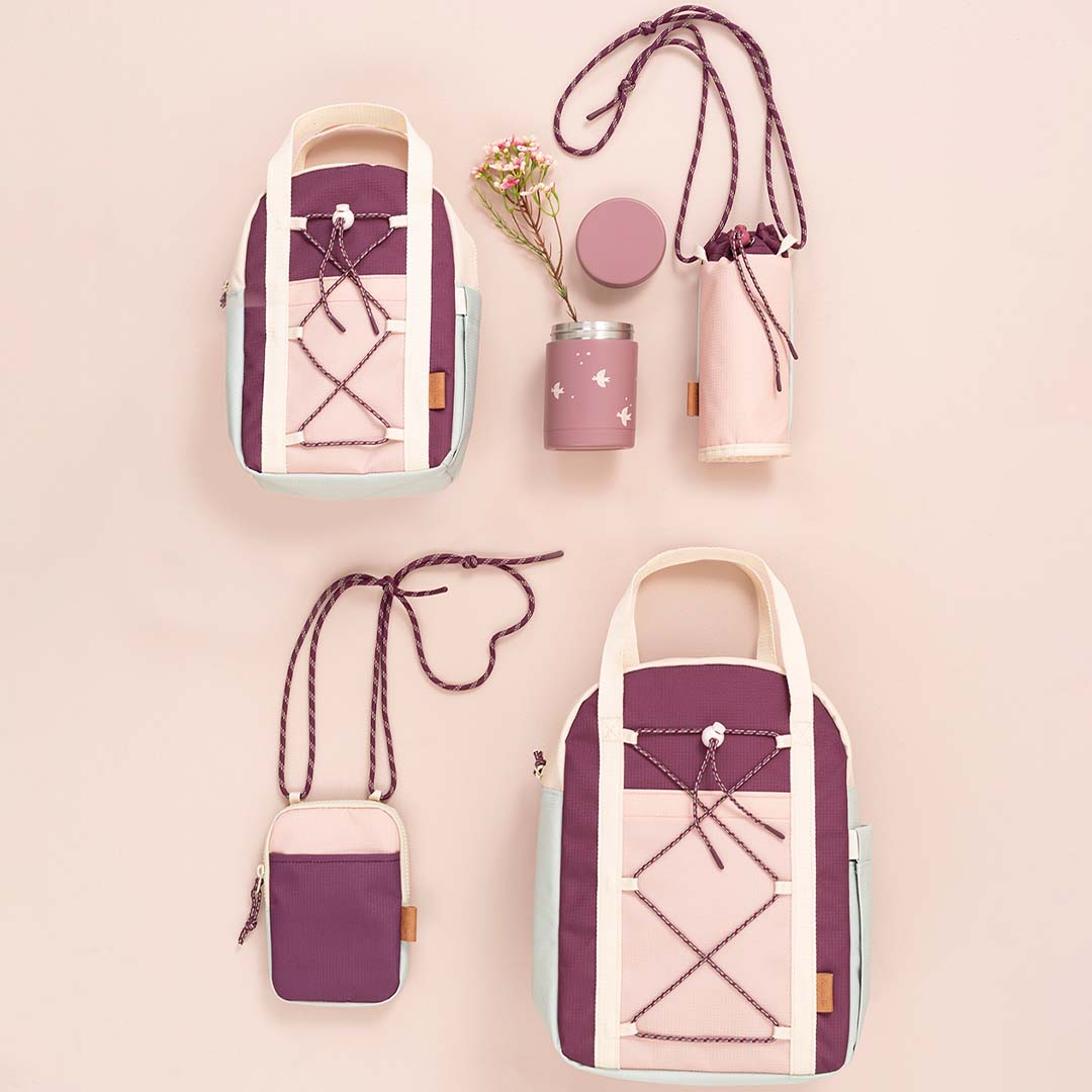 Een collectie Fresk peuterrugzakken en bijpassende accessoires in cameo rose, waaronder een thermos en een schoudertasje.
