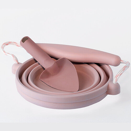 De roze Scrunch opvouwbare siliconen emmer en schepje, plat opgevouwen.