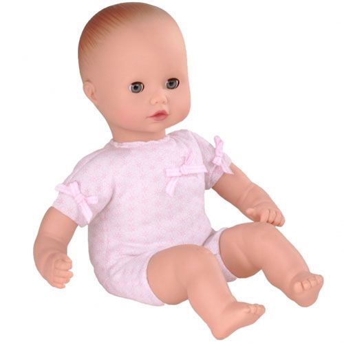 Gotz babypop in roze romper zittend.
