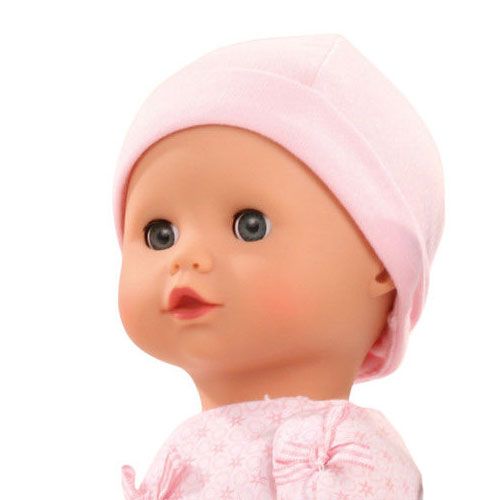 Detail van Gotz babypop met roze muts en romper, schuin van voren.