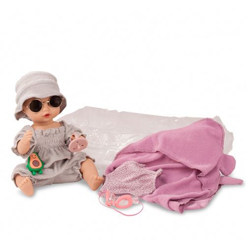 Götz badpop met grijze romper, hoedje, roze zonnebril, avocado speelgoed en roze zwemkleding en handdoek.