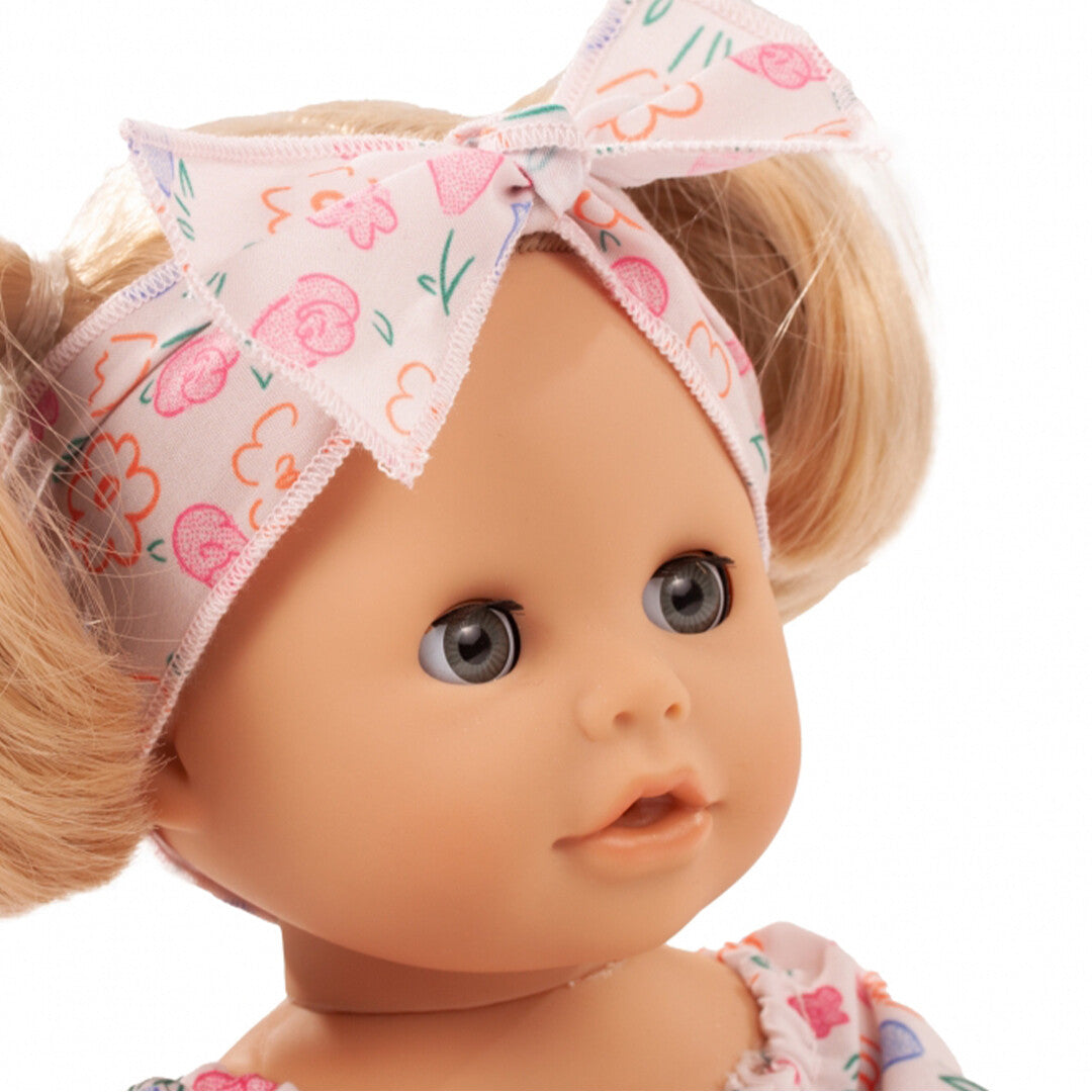 Detail van het gezicht van de badpop met blond haar en gebloemde hoofdband.