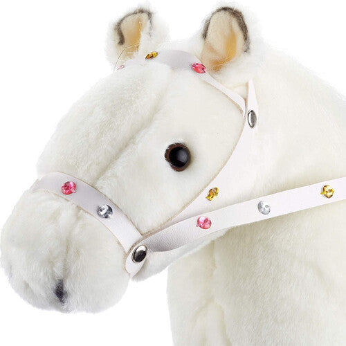 Detailopname van de kop van het Götz witte pluche poppenpaard, met hoofdstel versierd met gekleurde steentjes.