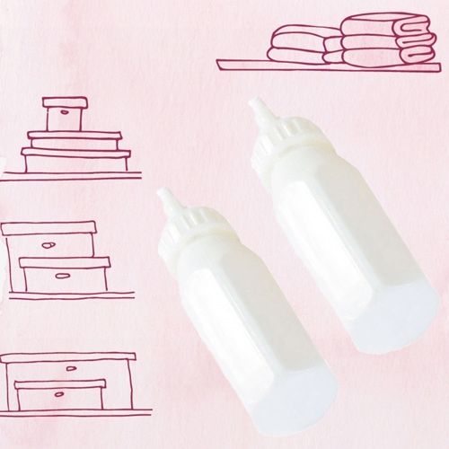 Twee witte Götz poppenzuigflessen op een roze achtergrond met illustraties van planken en dozen.