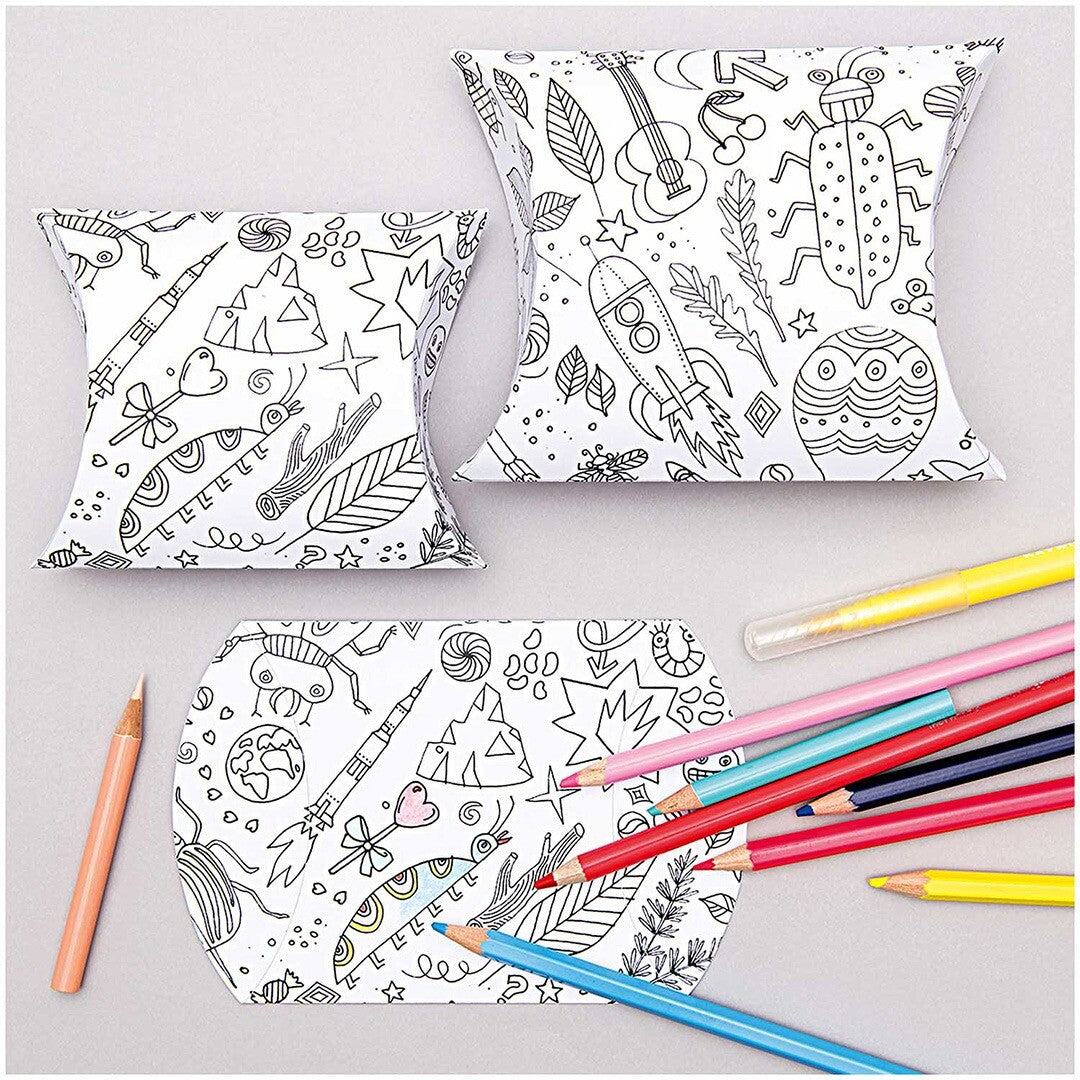 Twee gevouwen en één plat wit geschenkdoosje om in te kleuren, met diverse patronen van dieren, voertuigen en figuren, naast een set kleurpotloden.