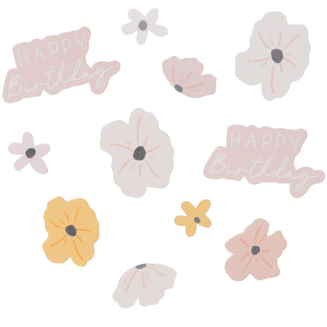 Detailfoto van Ginger Ray confetti met roze, gele en witte bloemvormen en 'Happy Birthday' tekst.