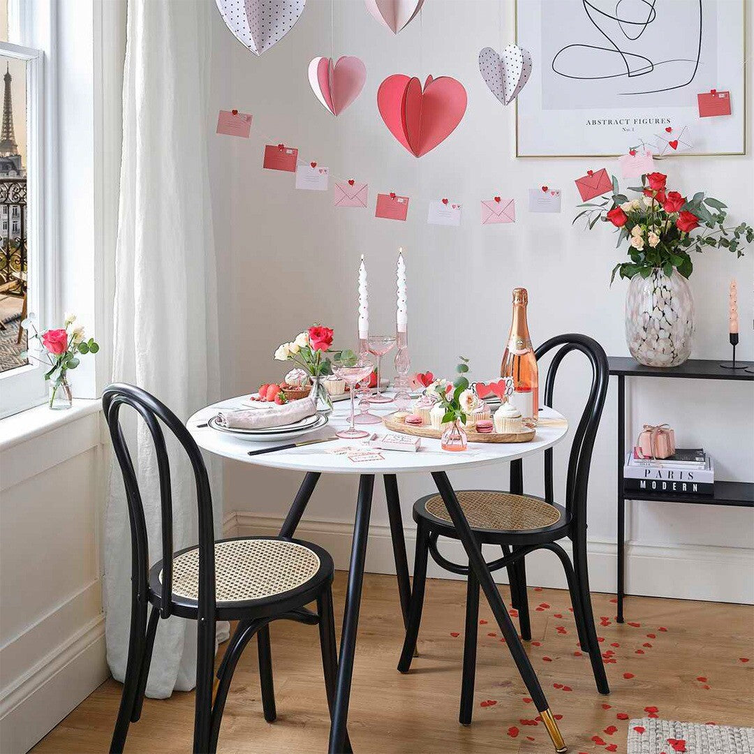 Ginger Ray feestversiering van hangende 3D papieren harten en een slinger met enveloppen in een romantisch gedecoreerde kamer.