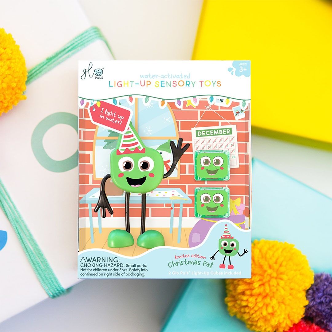De productverpakking van het Glo Pals kerst badspeelgoed met het groene figuurtje en lichtgevende blokjes.