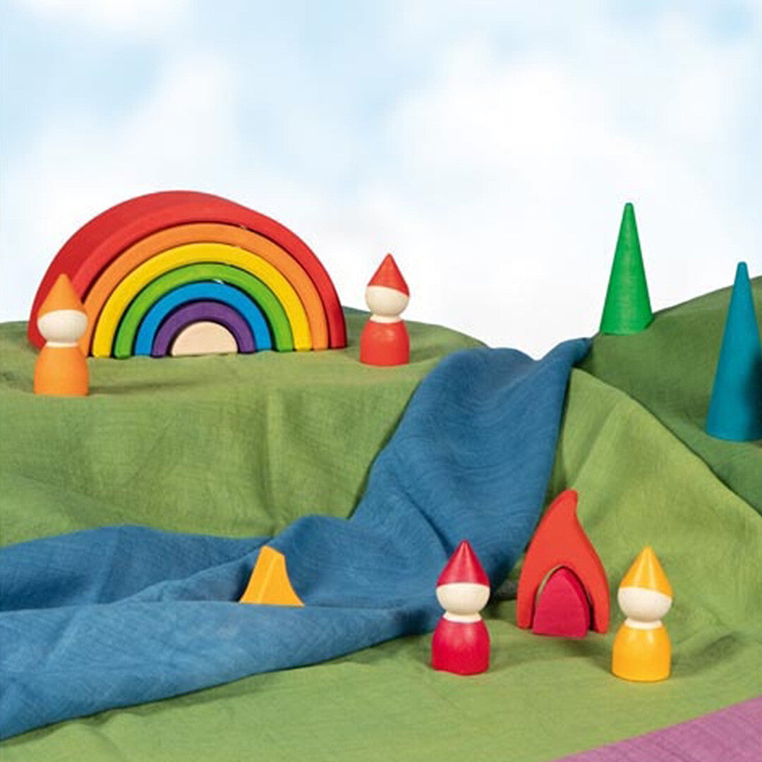 Goki houten regenboog stapeltoren in een speelscène met houten kabouters en bomen.