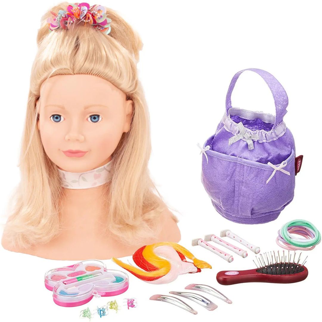 Götz styling make-up pop met blond haar en diverse stylingaccessoires, waaronder een paarse tas, borstel en make-up.