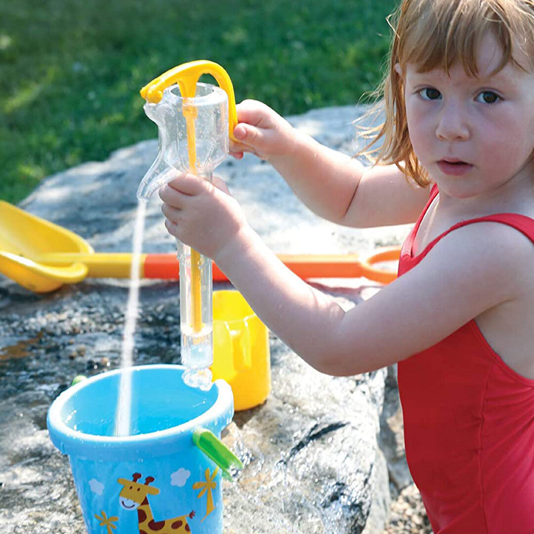 Een kind pompt water met de Bigjigs Gowi waterpomp in een blauwe emmer.
