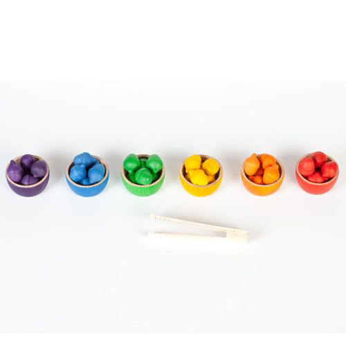 Grapat babyspeelgoed met zes houten bakjes in regenboogkleuren, elk gevuld met bijpassende houten eikeltjes, en een houten tang.