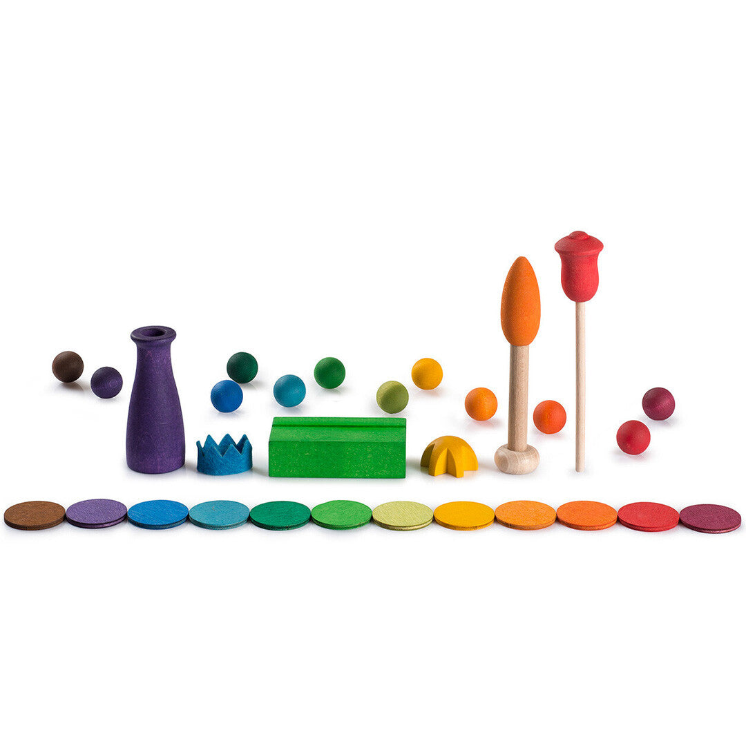 Grapat accessoires voor de eeuwige kalender, waaronder houten ballen, schijven, een vaas, een kroon en boomvormen in regenboogkleuren.