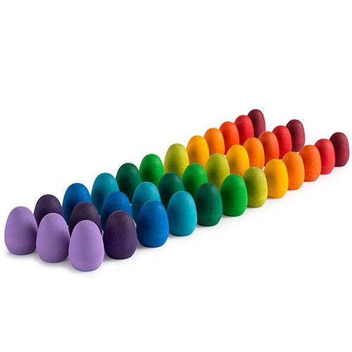Grapat houten speelgoed eieren in een regenboogopstelling, schuin gefotografeerd.