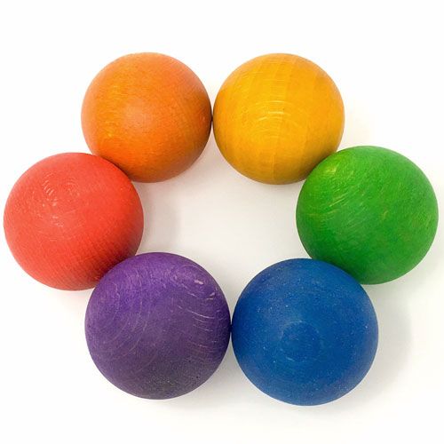 Grapat babyspeelgoed: zes houten regenboogballen in een cirkel.