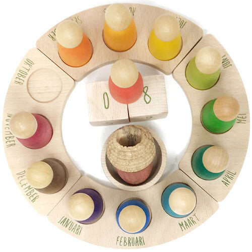 Grapat houten eeuwige kalender met 12 gekleurde peg dolls, maanden en datumblokjes, van bovenaf gefotografeerd.