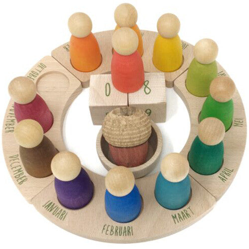 Grapat houten eeuwige kalender met 12 gekleurde peg dolls en datumblokjes in het midden, van bovenaf gefotografeerd.