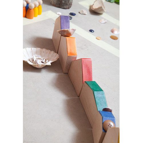 grapat houten huisjes met gekleurde daken en nins® poppetjes, opgesteld met schelpen.