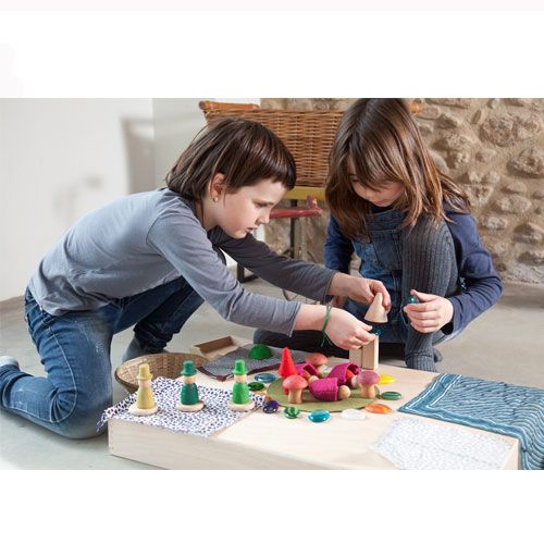 Twee kinderen spelen samen met Grapat houten nins® kabouters, paddenstoelen en viltstukken.