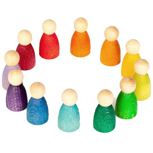 Grapat houten Nins poppetjes in regenboogkleuren, in een cirkel opgesteld.