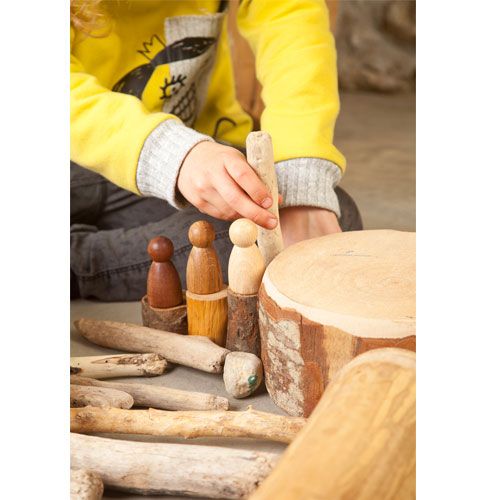 Een kind speelt met Grapat houten Nins® poppetjes en natuurlijke houten elementen.