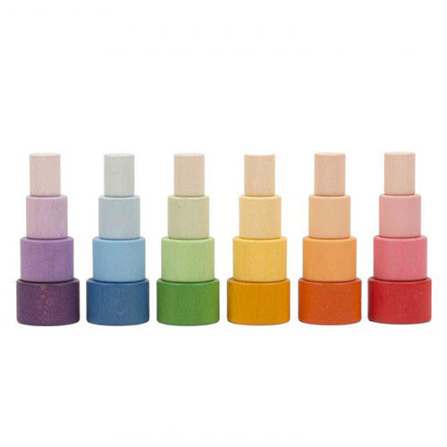 Zes Grapat houten stapelbakjes in regenboogkleuren, gestapeld tot torens.