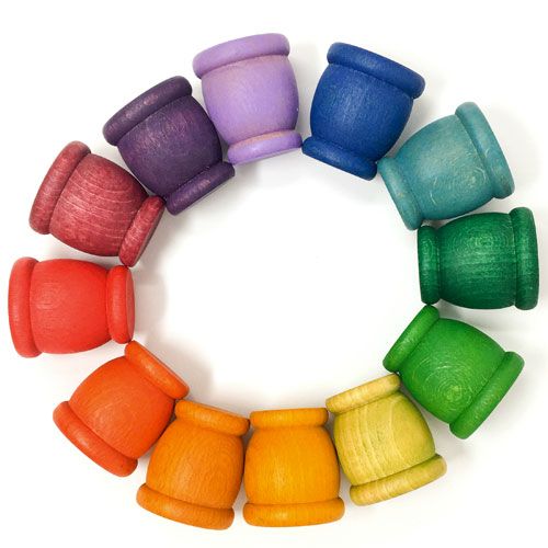 Twaalf grapat houten regenboog kuipjes voor sorteer- en stapelspeelgoed, in een cirkel gerangschikt.