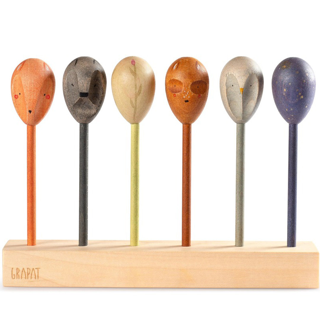 Grapat houten speelfiguren met zes dubbelzijdige poppen met dieren- en figuurgezichten in een houten standaard.