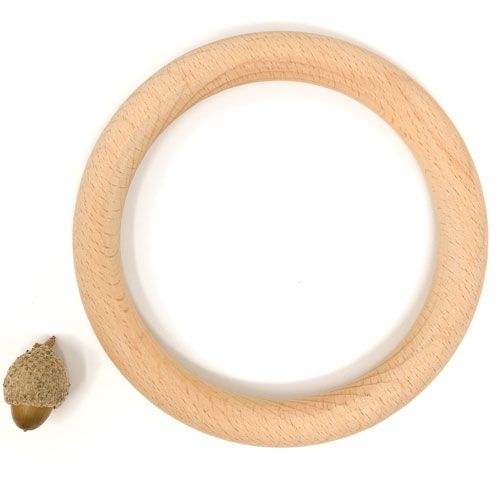 Grapat houten ring van 13 cm naast een eikel voor schaal.