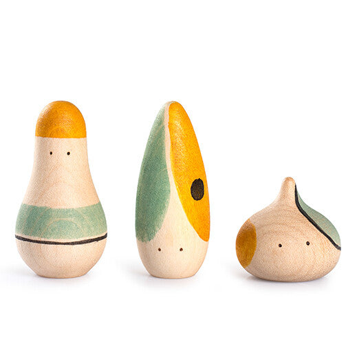 Grapat set van drie abstracte houten speelfiguren in beige, geel en groen op een witte achtergrond.