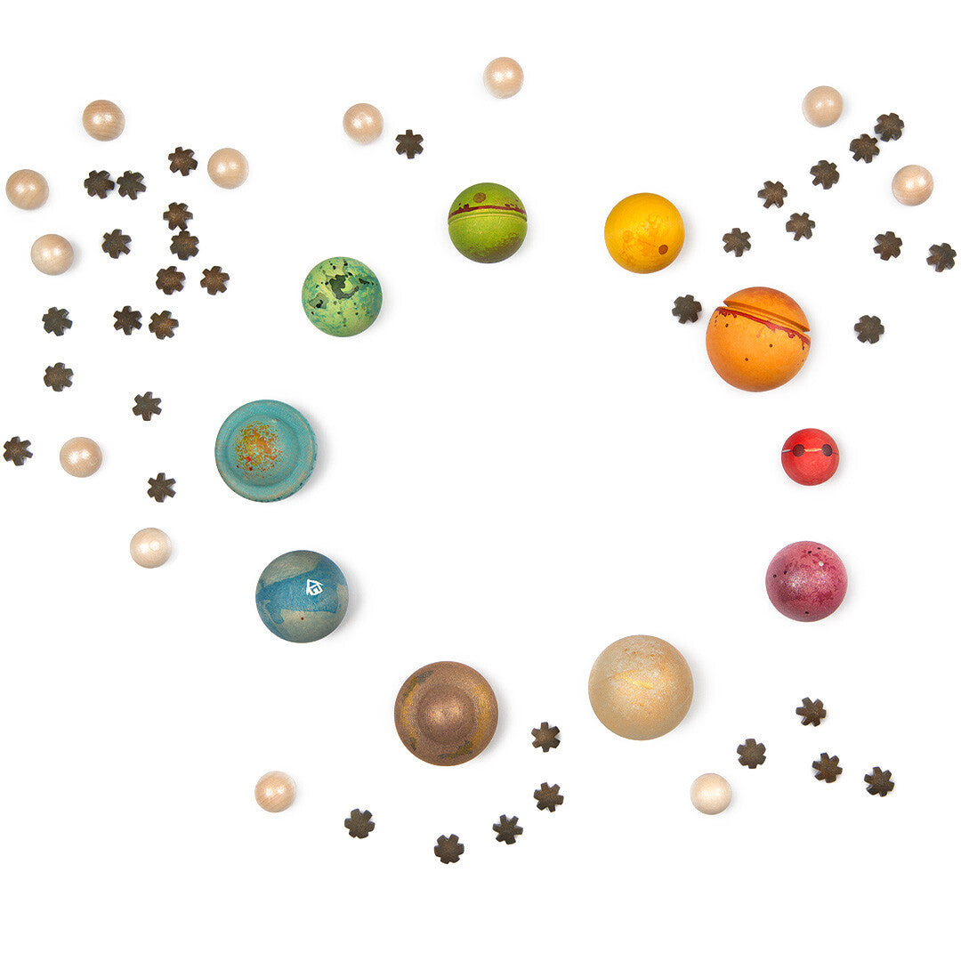 Grapat houten sterrenstelsel speelgoed met kleurrijke planeten en sterren, van bovenaf gefotografeerd.