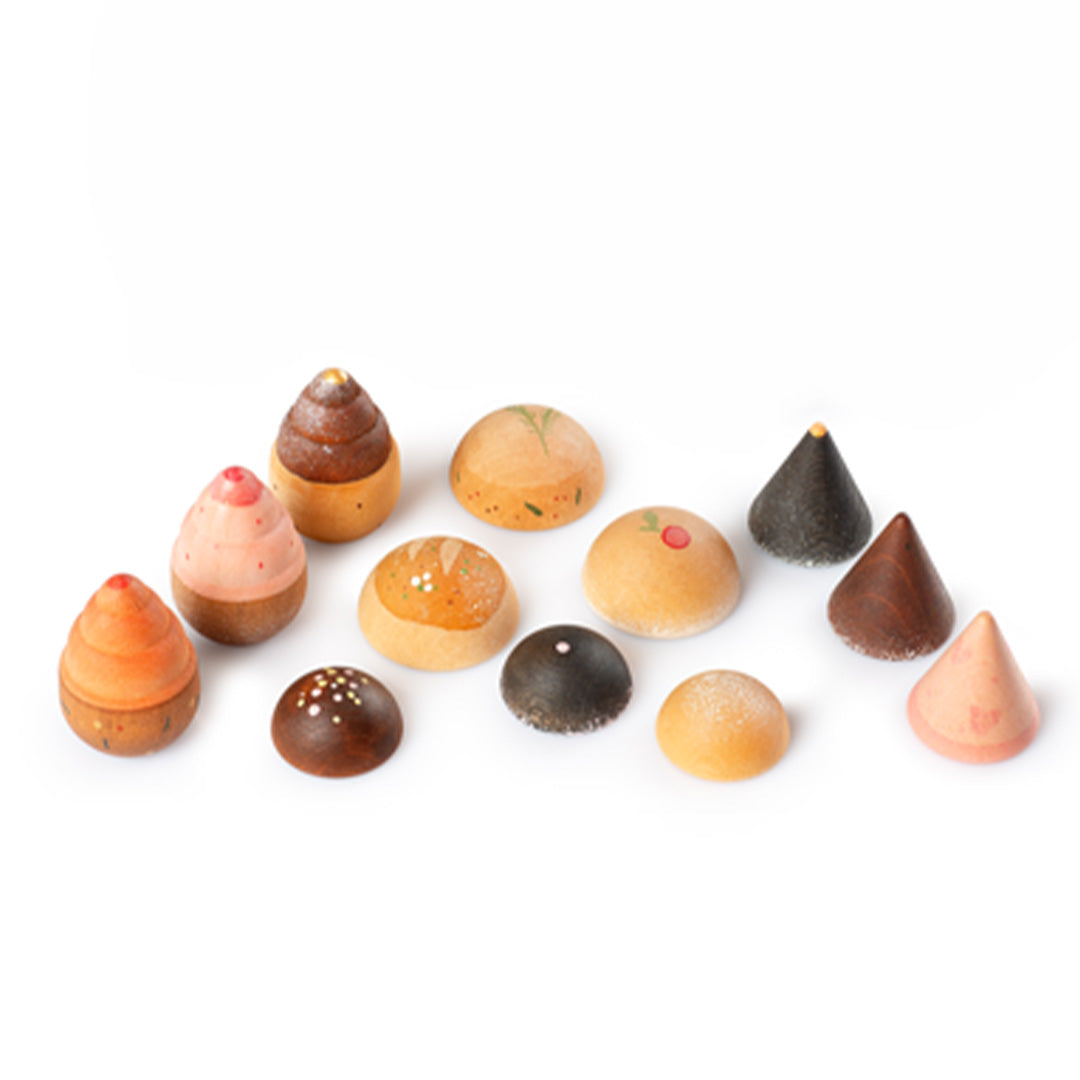 Grapat houten speelgoed bakwaren, 12 gekleurde houten gebakjes en chocolaatjes op een witte achtergrond.