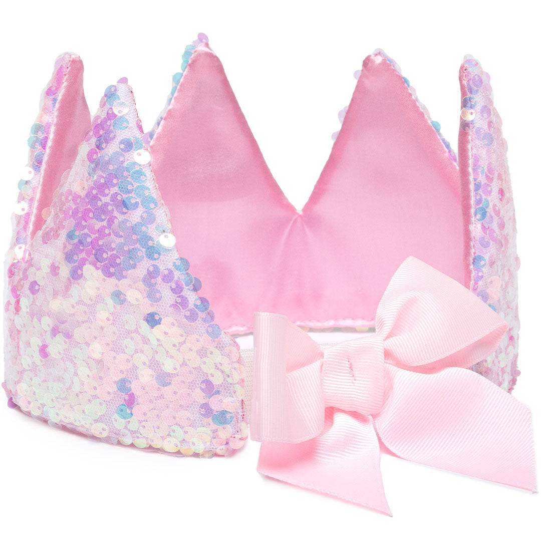 De Great Pretenders roze pailletten kinderkroon ligt op zijn zij, met een roze strik ernaast.