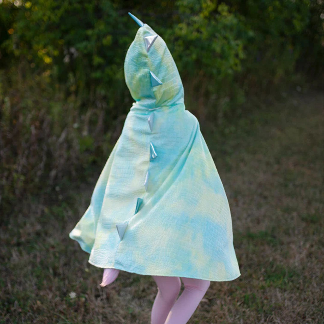 Kind van achteren gezien, rennend in een great pretenders groene draken verkleedcape met schubbenpatroon en stekels.