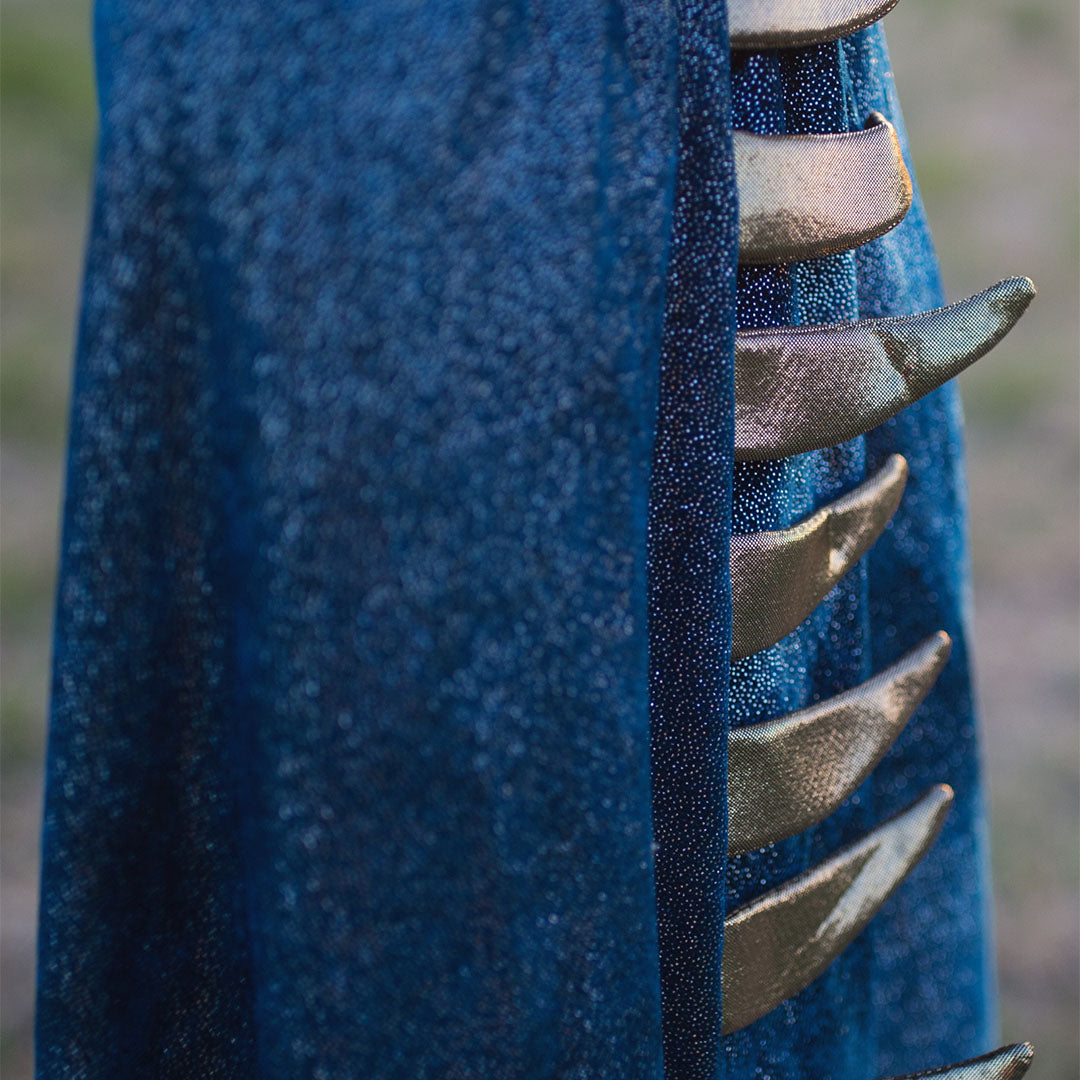 Detail van de blauwe draken verkleedcape met gouden stekels aan de zijkant.