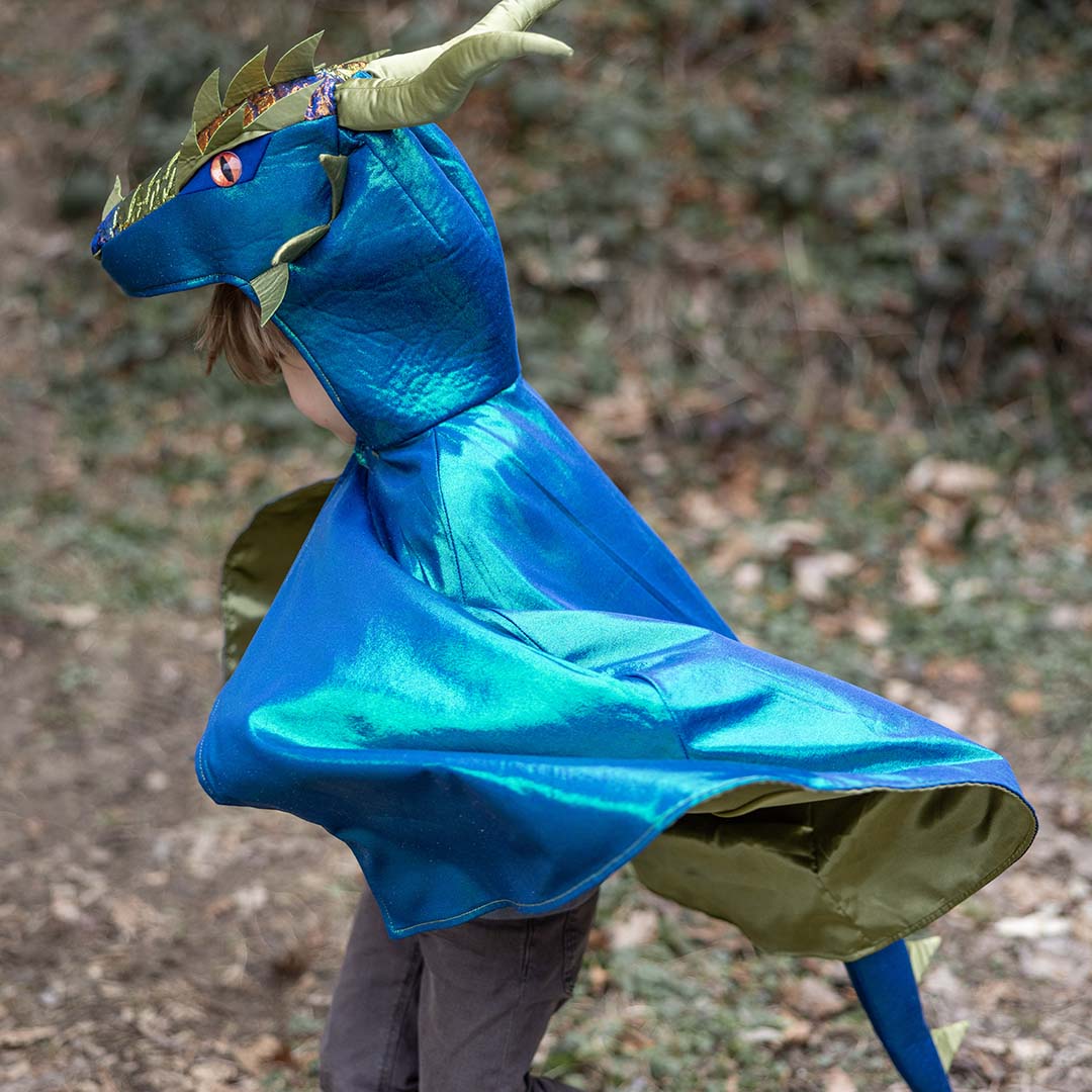 Een kind loopt in de Great Pretenders verkleedcape draak emerald, met de glanzende stof die wappert.