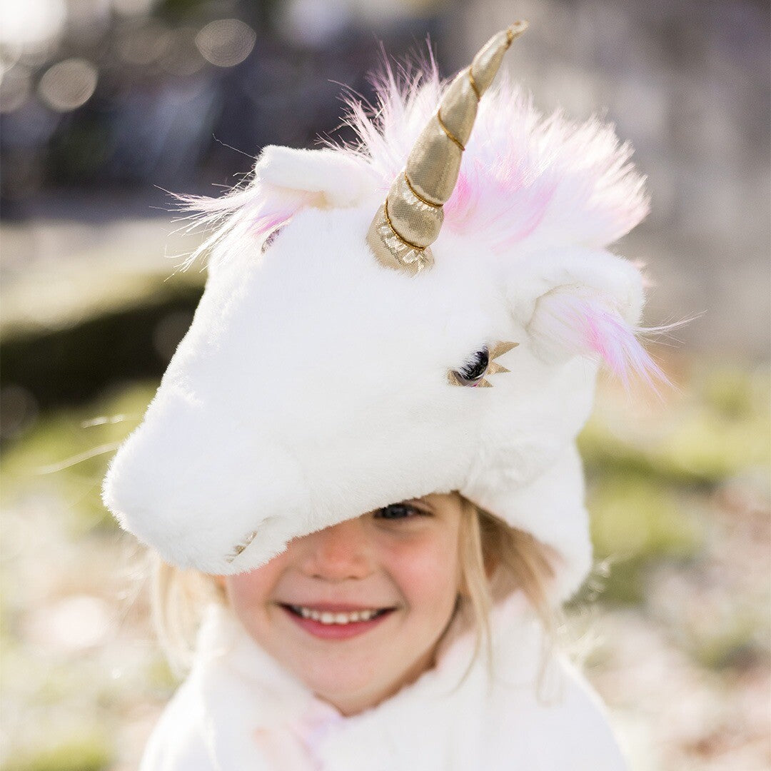 Een meisje met de witte eenhoorn verkleedcape, waarbij de capuchon haar ogen deels bedekt.