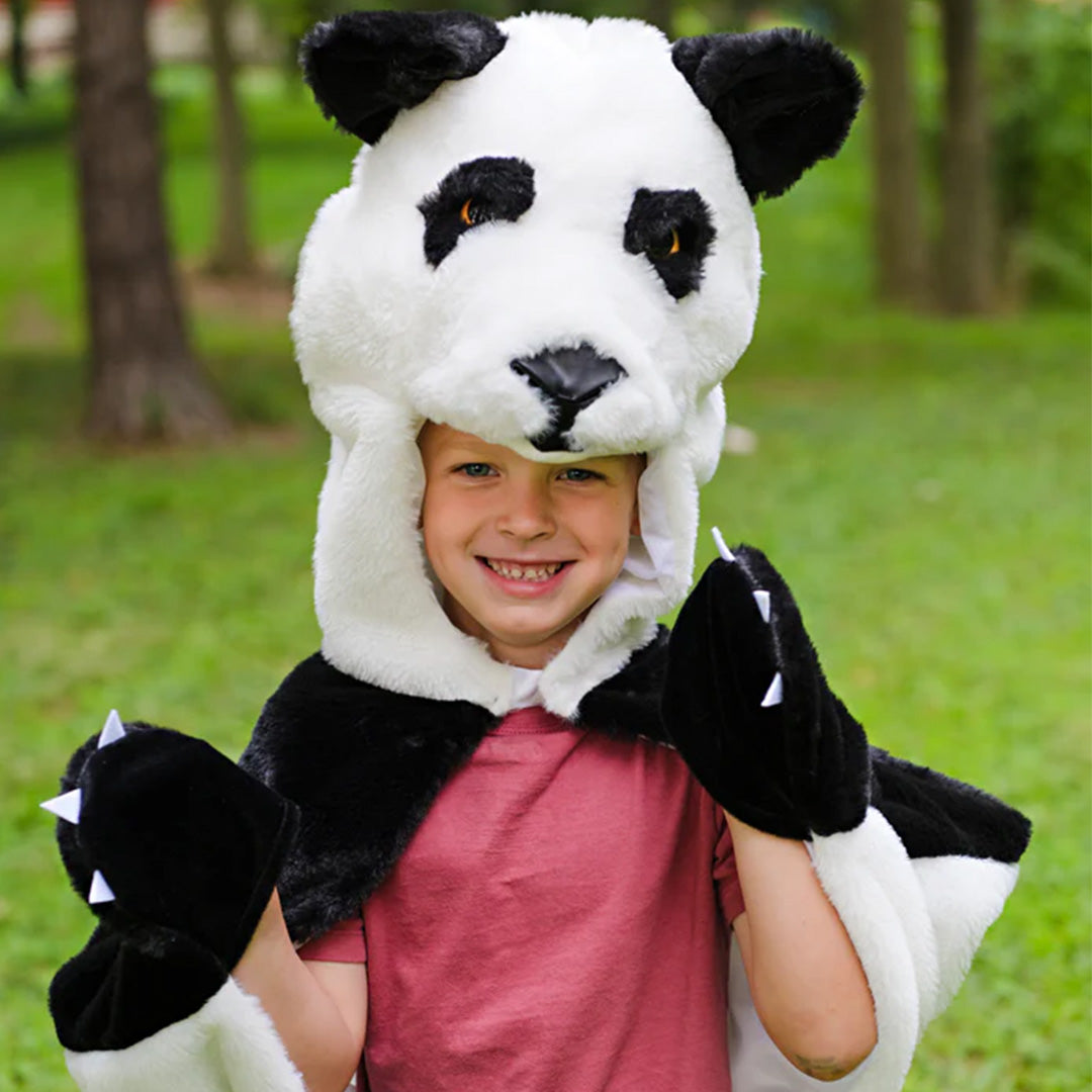 Lachende peuter draagt de Great Pretenders panda verkleedcape en toont de pandapootjes.