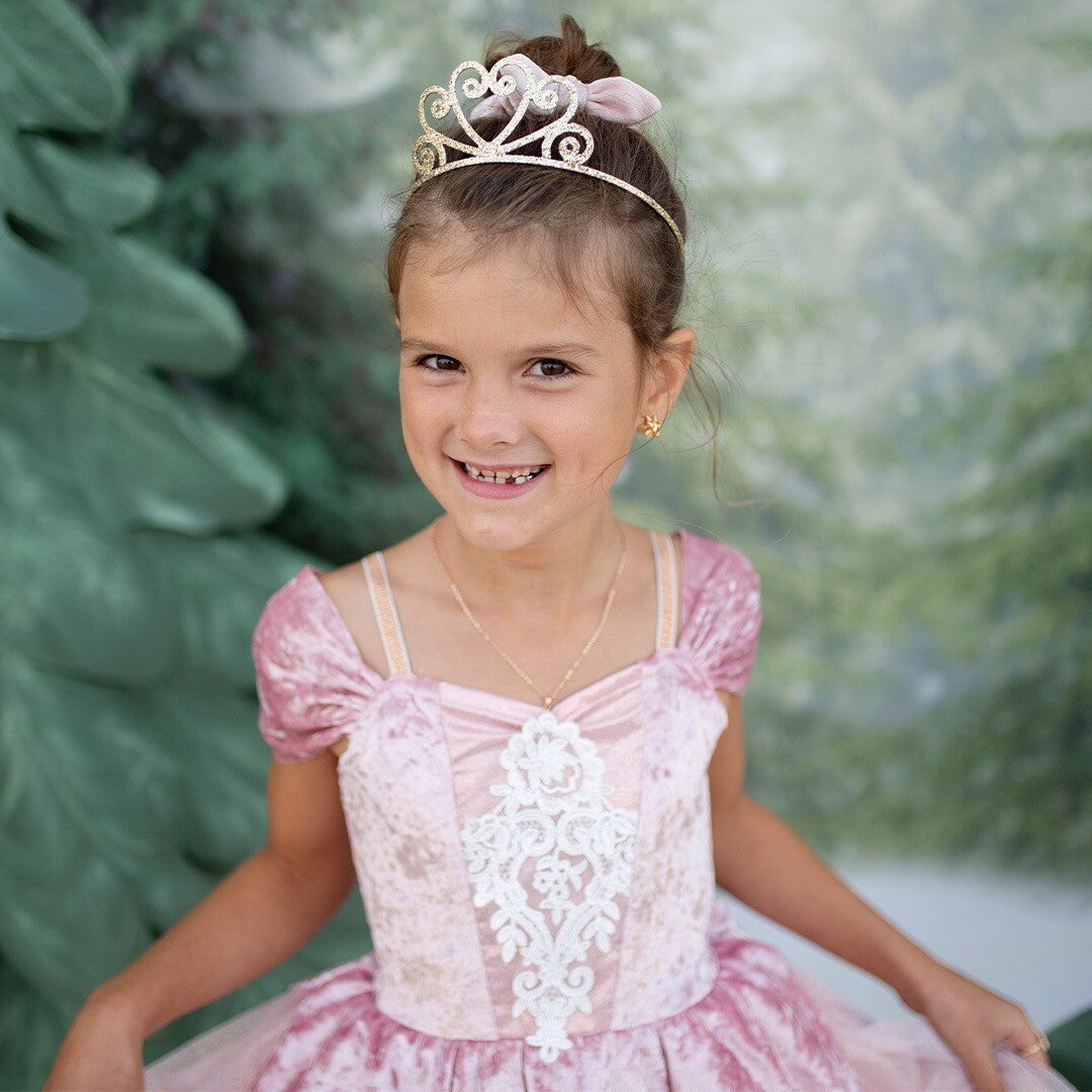 Close-up van een lachend meisje dat de dusty rose prinsessen verkleedjurk met kant en een tiara draagt.
