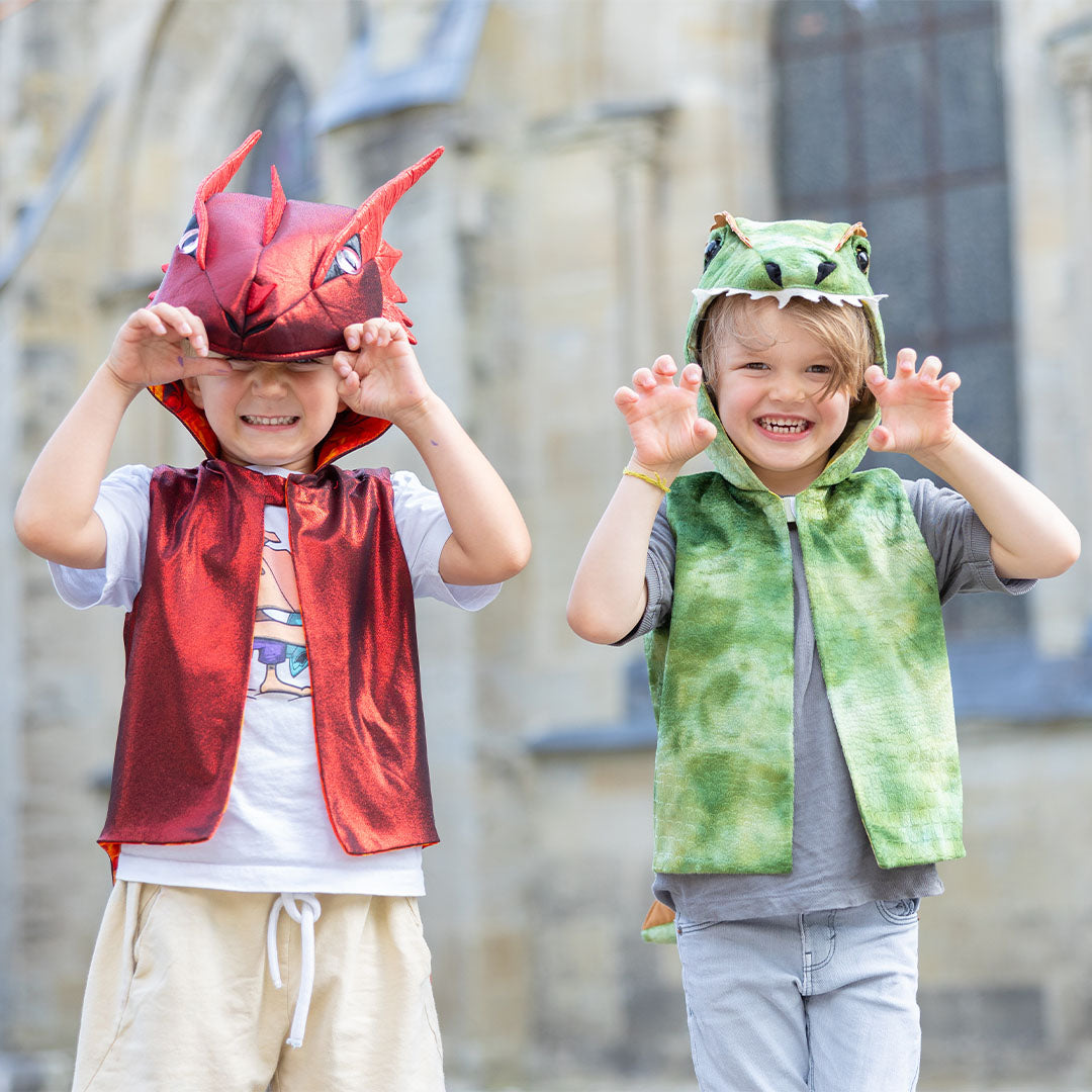 Twee lachende kinderen, één in een Great Pretenders groen dino verkleedvest en één in een rood drakenvest, maken klauwgebaren.