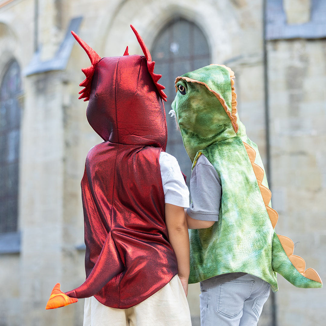 De achterkant van twee kinderen in een Great Pretenders groen dino verkleedvest en een rood drakenvest, met hun staarten zichtbaar.