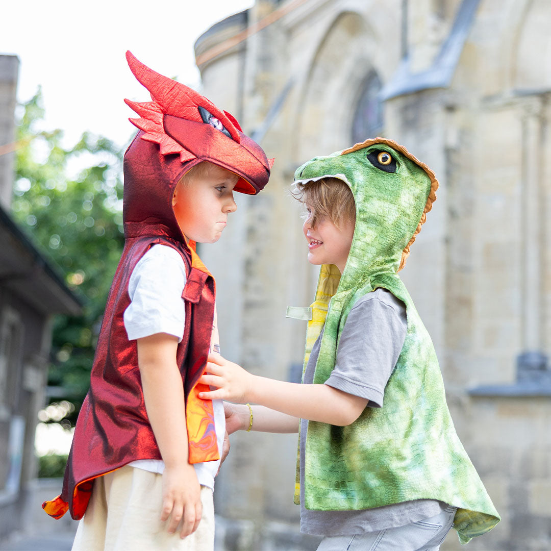 Twee kinderen in een Great Pretenders groen dino verkleedvest en een rood drakenvest staan tegenover elkaar.