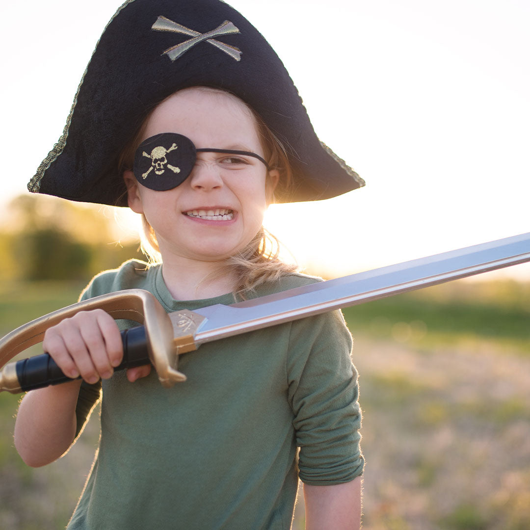 Kind met Great Pretenders piraten ooglapje en hoed, met een speelse uitdrukking en een speelgoedzwaard.