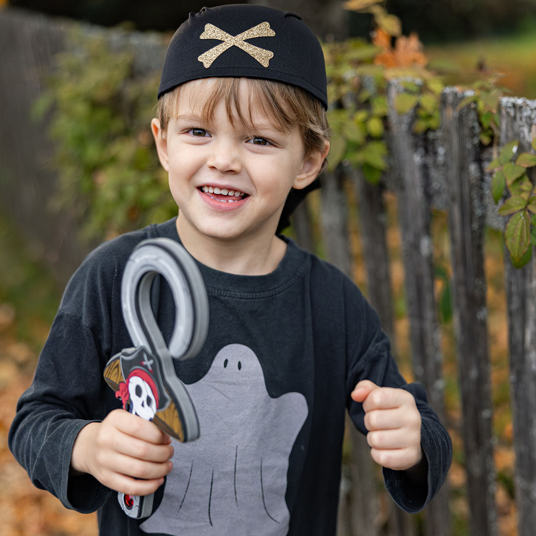 Een vrolijk kind met piratenbandana en piratenhaak in de hand.