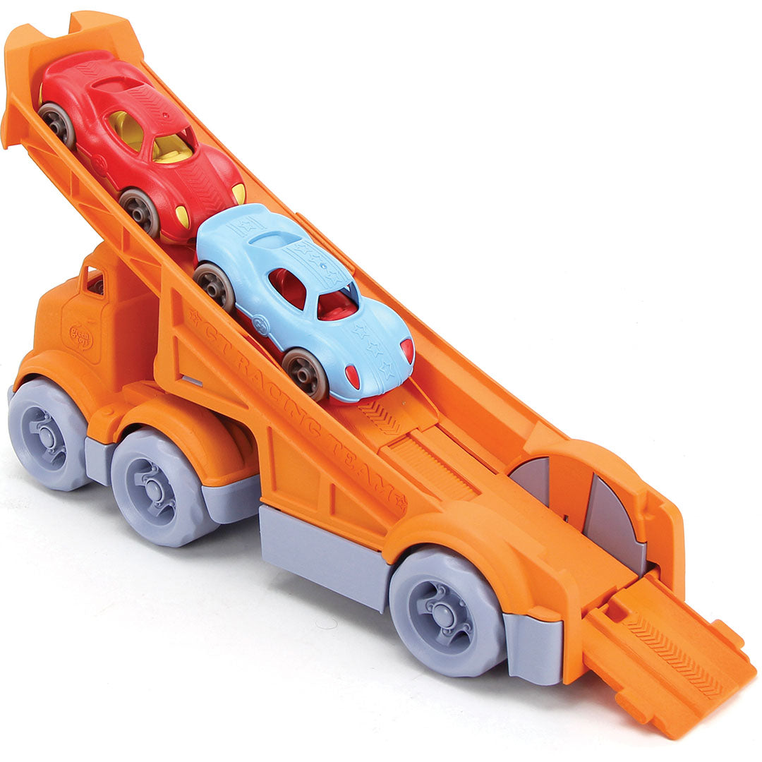 Green Toys speelgoedvrachtauto met de laadklep omhoog, een rode en een blauwe racewagen erop.